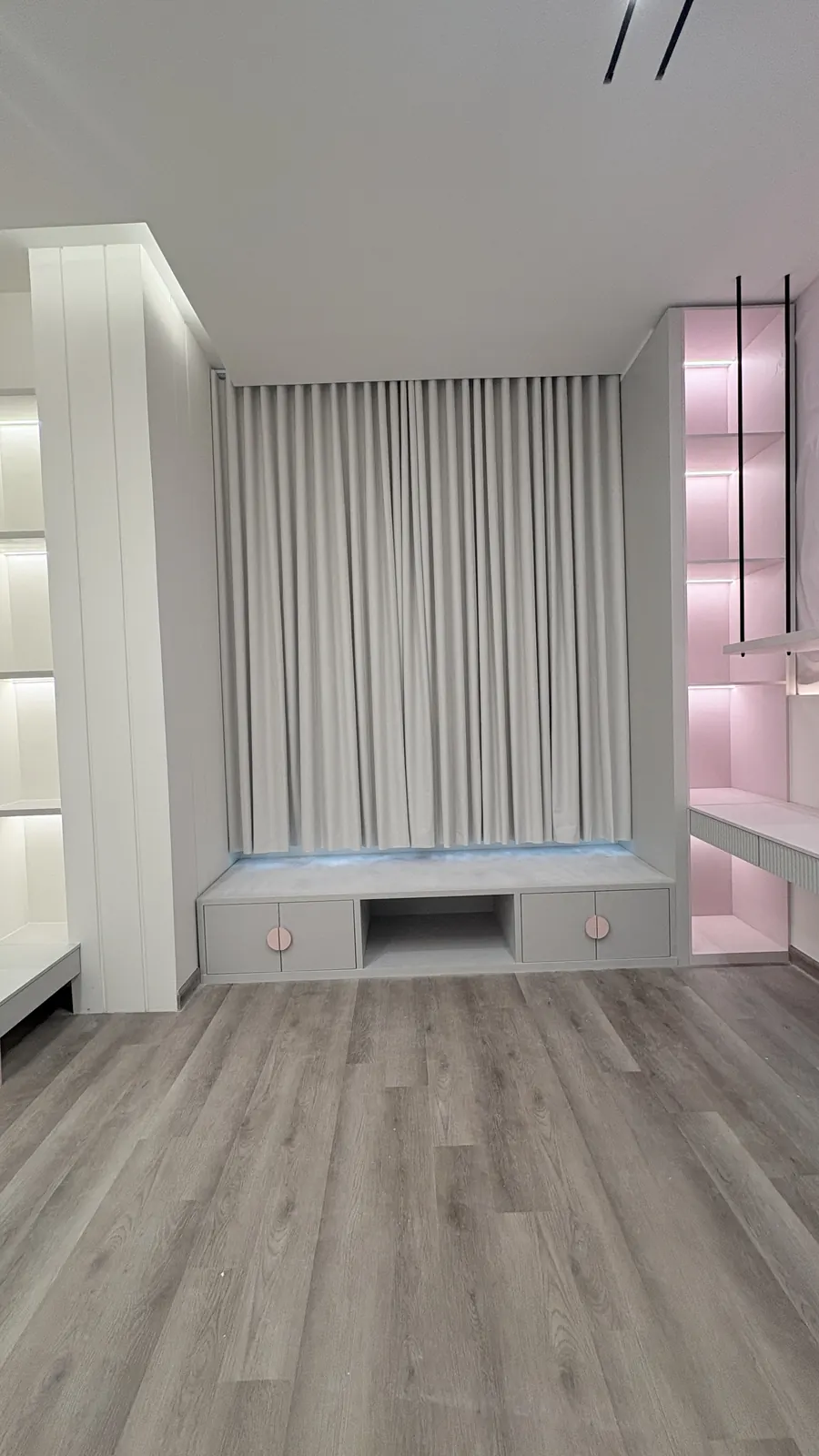 Blackout curtains closed in a kids' room with built-in shelves in Doha