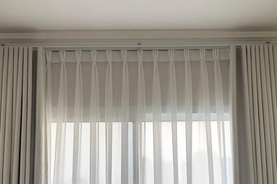 Made-to-measure curtains with a pinch pleat heading on a track in a Doha home
