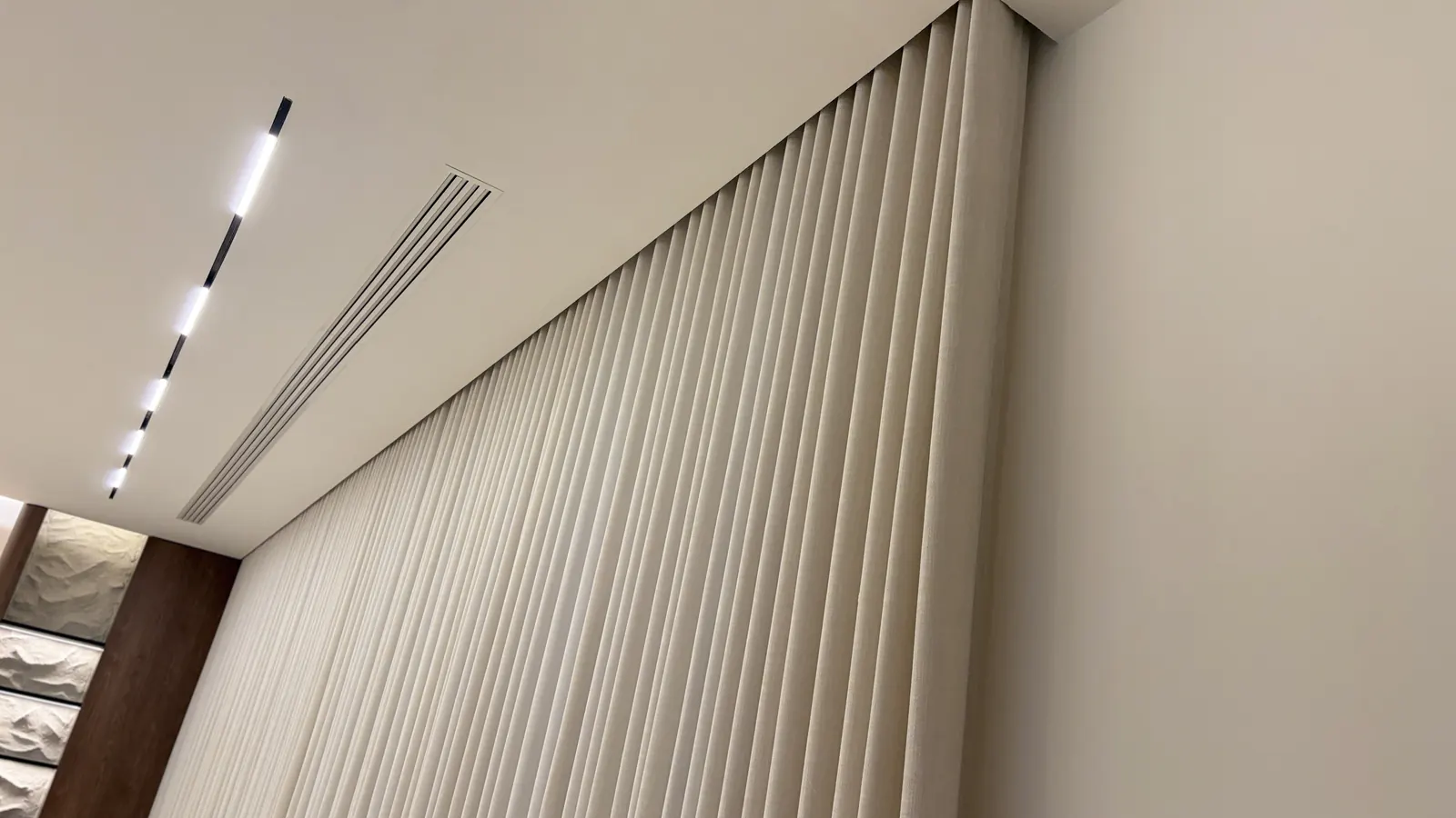 White wave sheer on a ceiling track under linear lights in Doha